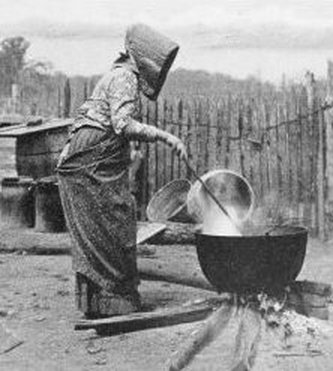 A woman soap maker stirs a boiling pot of lye soap at the Ozark